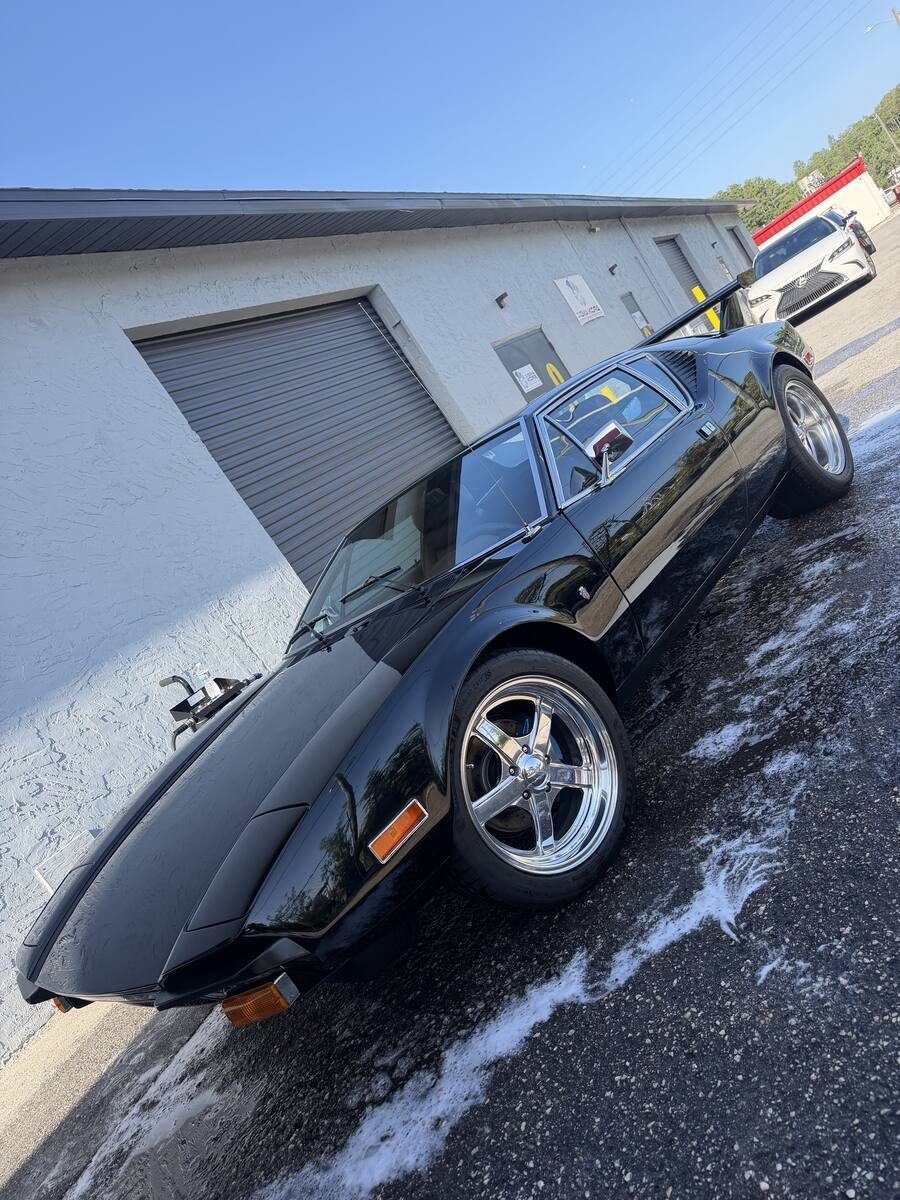 Detailed classic black sports car with chrome wheels